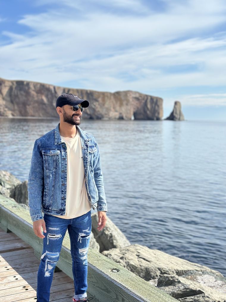 Standing on a boardwalk in front of Percé Rock, Quebec